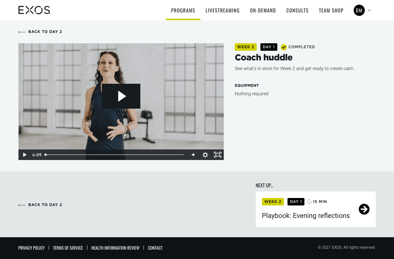 EXOS activity video page: Coach huddle video with week, day and completed badges, equipment note and a Next up card.